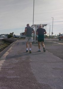 Two joggers running on pavement